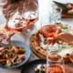 Friends enjoy a dinner party with pizza and rose wine in a bar or a restaurant.
